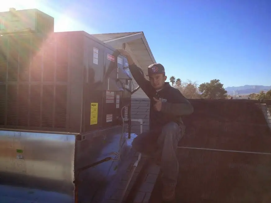 HVAC technician performing Air Duct Repair on a rooftop unit in Louisville